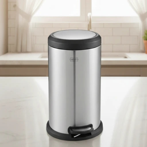 Silver trash can with black lid on a kitchen counter
