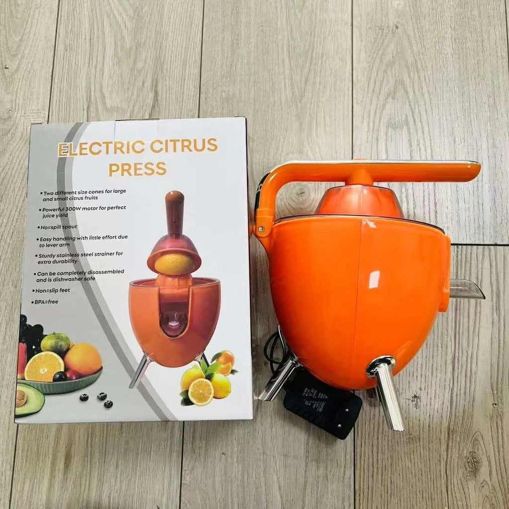 Orange electric citrus press on a wooden surface with a product description card.
