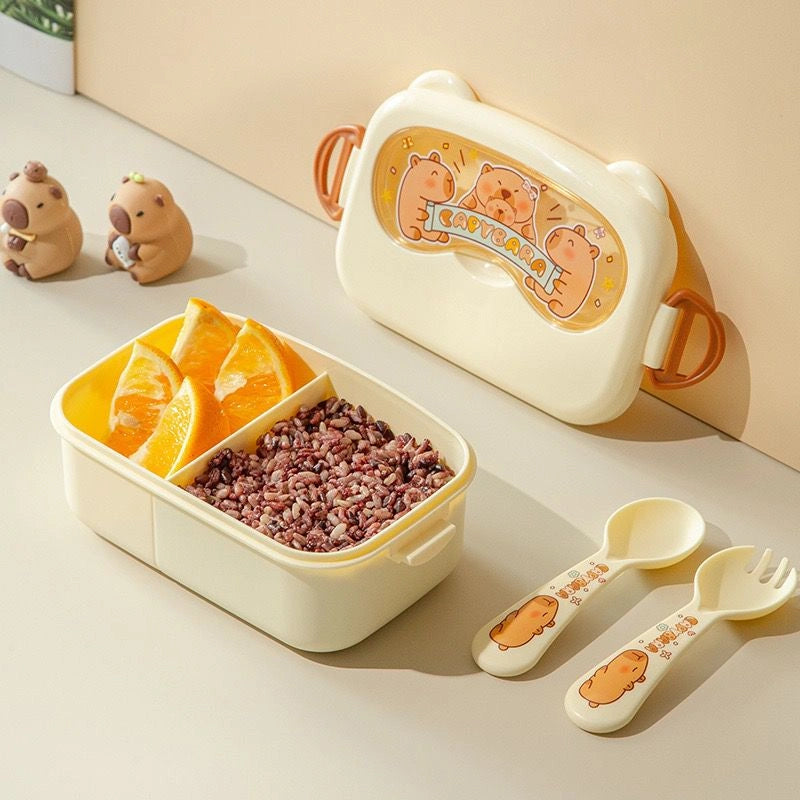 Children's lunch box set with cartoon design, including a container with compartments, spoon, and fork on a light background.