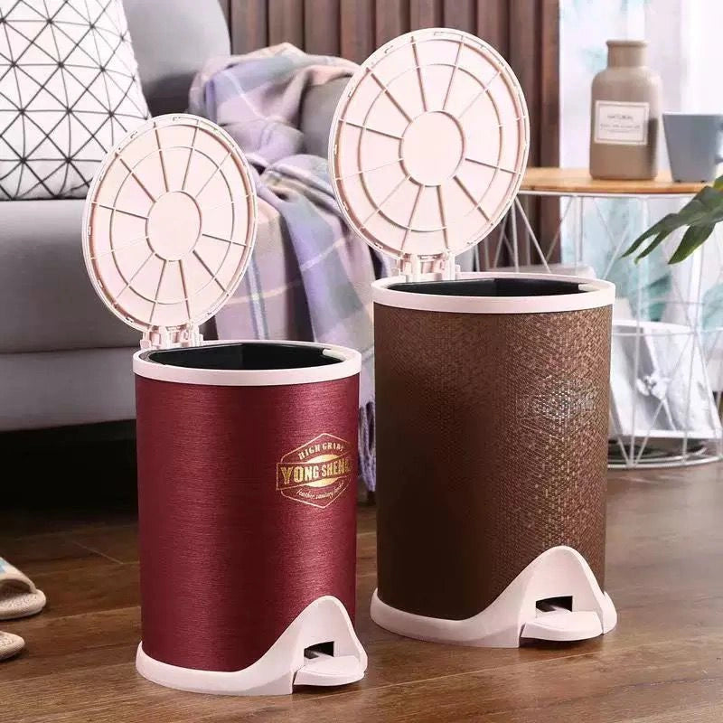 Two dustbins, one red and one brown, with white lids on a wooden floor.