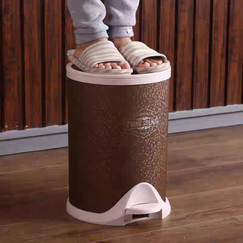 Person using a foot pedal bin with brown leather texture on a wooden floor.